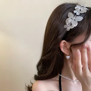 Close-up detail of a vintage silver metal butterfly headband on wavy brown hair.