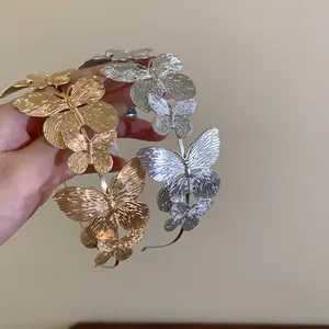 Detail view of vintage metal butterfly headbands in elegant gold and silver finishes.