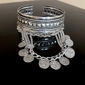 Macro view of vintage silver coin tassels on bohemian style cuff bracelet