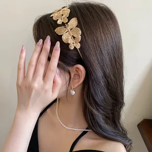 Close-up detail of a vintage French style gold metallic butterfly headband worn on dark hair.
