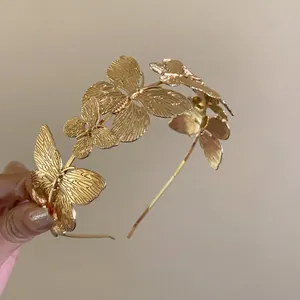 Close-up detail of a vintage golden metallic butterfly headband with intricate engraving