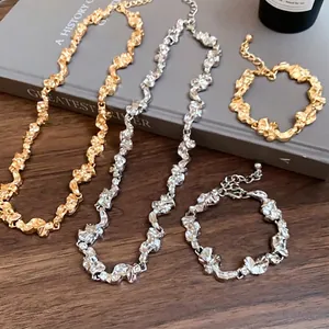 Conjunto de collar y pulsera de metal arrugado irregular en acabado oro y plata