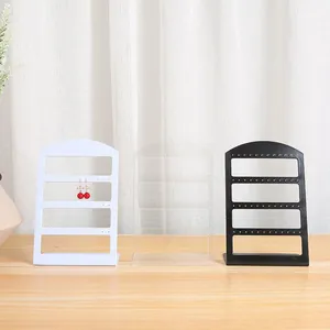 Juego de soportes para pendientes minimalistas en blanco, transparente y negro.