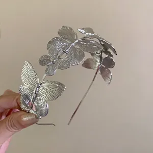 Close-up showing the detailed silver butterfly embellishments on a metal headband