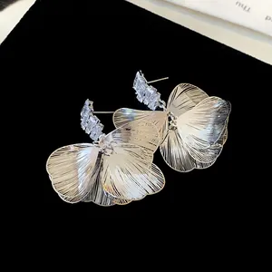 Primo piano dettagliato di eleganti orecchini a petalo d'argento con zirconi scintillanti.