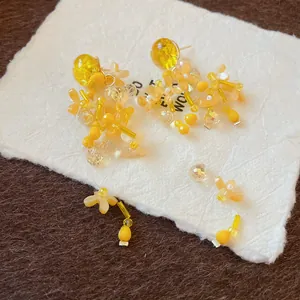 Vista ravvicinata dettagliata di orecchini a nappa con petali gialli fatti a mano su carta