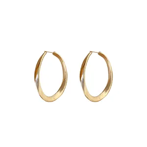 Elegant gold-tone twisted oval hoop earrings featuring a minimalist geometric design