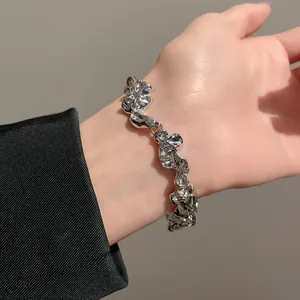 Primer plano de una pulsera de metal plateado con pliegues irregulares