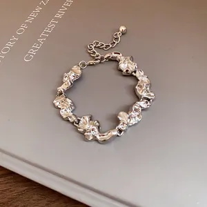 Primer plano de pulsera de metal arrugado irregular con cadena