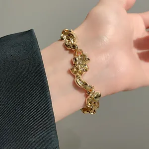 Vista detallada de una pulsera dorada maciza con textura de pliegues irregulares