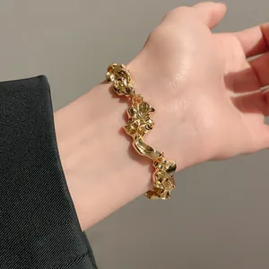 Vista macro detallada de una pulsera de metal dorado arrugado irregular en la muñeca de mujer