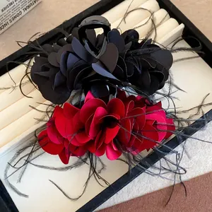 Nahaufnahme eleganter französischer Rosen-Haarklammern mit zarten schwarzen Federn