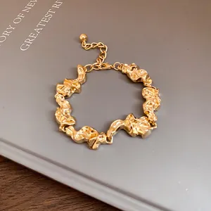 Vista detallada de pulsera de metal dorado con eslabones arrugados irregulares