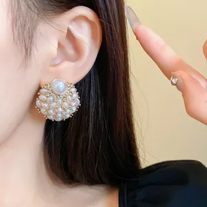 Detailansicht französischer runder Perlenohrstecker mit glänzenden Diamanten.