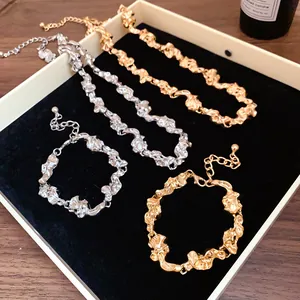 Vista detallada de collares y pulseras de metal arrugado irregular en oro y plata