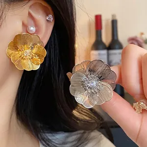 Orecchini a perno a forma di fiore metallico placcati in oro con centri in zircone