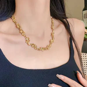 Primer plano de un collar metálico dorado arrugado irregular en una modelo