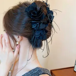 Detailansicht einer eleganten schwarzen Rosen-Haarklammer mit zarten schwarzen Federn