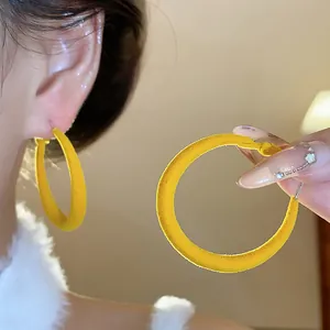 Orecchini a cerchio floccati gialli con design circolare e consistenza vellutata