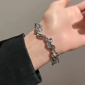 Primer plano de una pulsera de plata arrugada irregular en la muñeca con textura