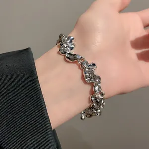 Primer plano detallado de una pulsera de metal arrugado con textura de líquido