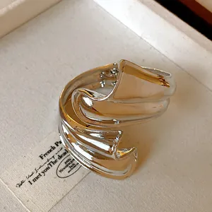 Macro view of punk style irregular wavy silver metallic cuff bracelet with high gloss finish
