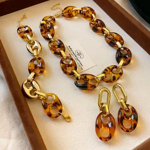 Detailed view of a vintage tortoise shell acrylic chain necklace and earrings set