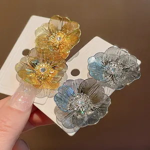Vista dettagliata di orecchini a fiore placcati oro e argento con centro in zircone.