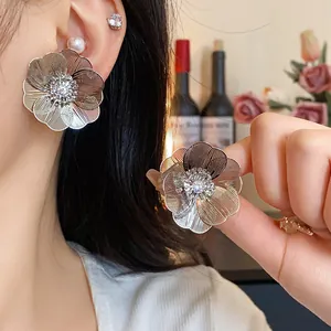 Dettaglio degli orecchini a fiore placcati in oro con zircone scintillante