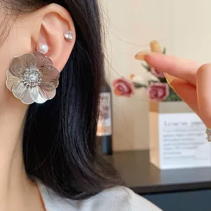 Dettaglio ravvicinato di un grande orecchino a fiore in argento con zirconi e perle