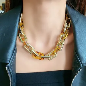 Vintage chunky gold chain necklace with leopard resin links worn with a black jacket
