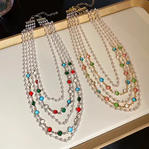 Detailed view of multi-layer pearl necklaces with colorful gemstones in gold and silver tones.