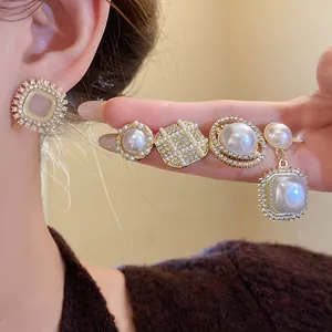 Detailed view of French vintage pearl and rhinestone earring set in gold finish