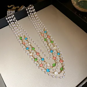 Close-up of multi-layer French vintage necklace with pearls and colorful round gemstones.