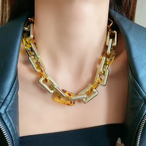Close-up view of a chunky gold metal and leopard print resin link chain necklace for women
