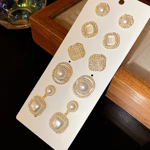 Detail showing a French vintage earring set with pearls and rhinestones on a display card.