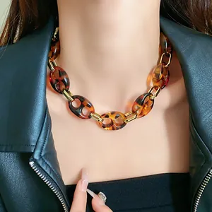 Close-up of retro leopard print chain necklace with gold links on black leather