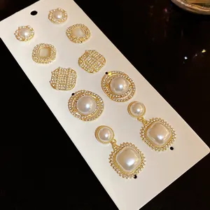 Detailed macro view of vintage pearl and rhinestone earring set on a white card