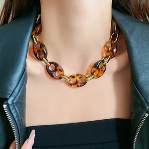 Detailed macro view of vintage leopard print chunky chain necklace worn with leather jacket
