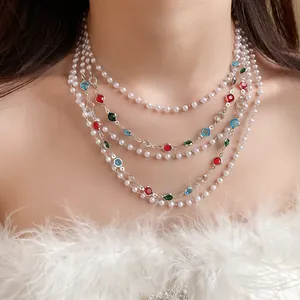 Macro detail of a French vintage multi-layered pearl necklace with vibrant colored gemstones