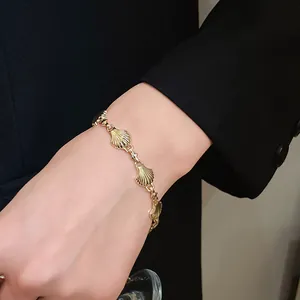 Vintage gold-tone bracelet featuring shell-shaped links on model's wrist