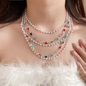 Close-up of multi-layered pearl necklace with colorful faceted stones on model