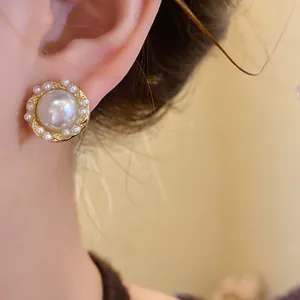 Elegant French vintage style round pearl stud earrings with gold textured metal base