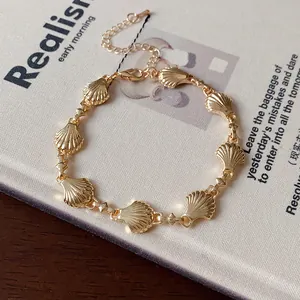 Detailed close-up of a vintage-style gold shell link bracelet on a book
