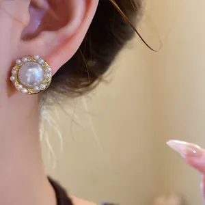 Close-up of elegant French vintage pearl stud earring on model's ear