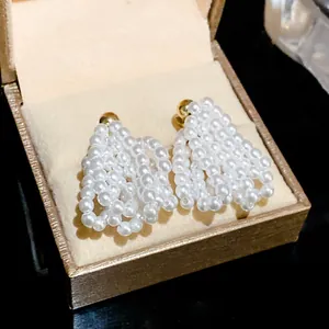 Detailed view of elegant hollow heart-shaped pearl drop earrings displayed in a box