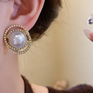 Close-up of elegant pearl and rhinestone round earrings in a French retro style