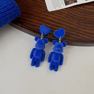 Vista macro dettagliata di orecchini a forma di orso floccato blu Klein con borchie a cuore