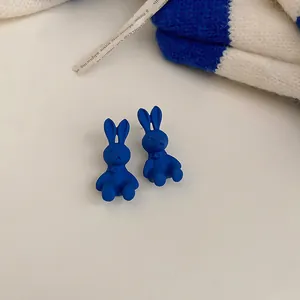 Dettaglio ravvicinato degli orecchini a lobo minimalisti a coniglio blu Klein opaco