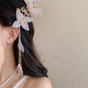 Dettaglio di elegante fermaglio per capelli a fiore rosa con perla e nappa lunga